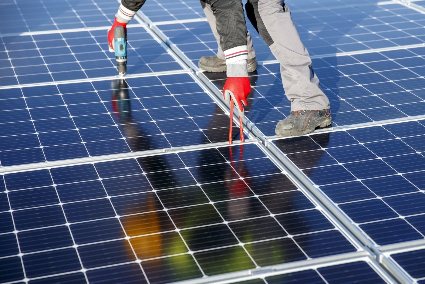 Des ouvriers posent des panneaux solaires sur le toit du stade de Geneve, ce mardi 12 novembre 2019 a Geneve. Une centrale solaire est en cours d'installation sur le toit du Stade de Geneve par les Services industriels de Geneve (SIG). Les quelque 5000 m2 de panneaux photovoltaiques permettront de produire 1,1 GWh d'electricite, soit l'equivalent de la consommation de 367 menages. (KEYSTONE/Salvatore Di Nolfi)