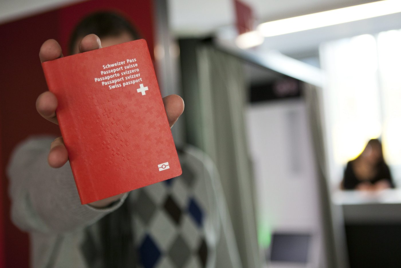 Un homme tient son nouveau passeport Suisse biometrique au nouveau centre de biometrie au Flon, ce vendredi 21 janvier 2011 a Lausanne. Ce centre va recolter les donnees biometriques pour les passeports suisse ainsi que pour les cartes de sejour biometrique. A partir du 24 janvier 2011, les titres de sejour biometriques pour les ressortissants etrangers des Etats tiers deviennent obligatoires. (KEYSTONE/Anthony Anex)