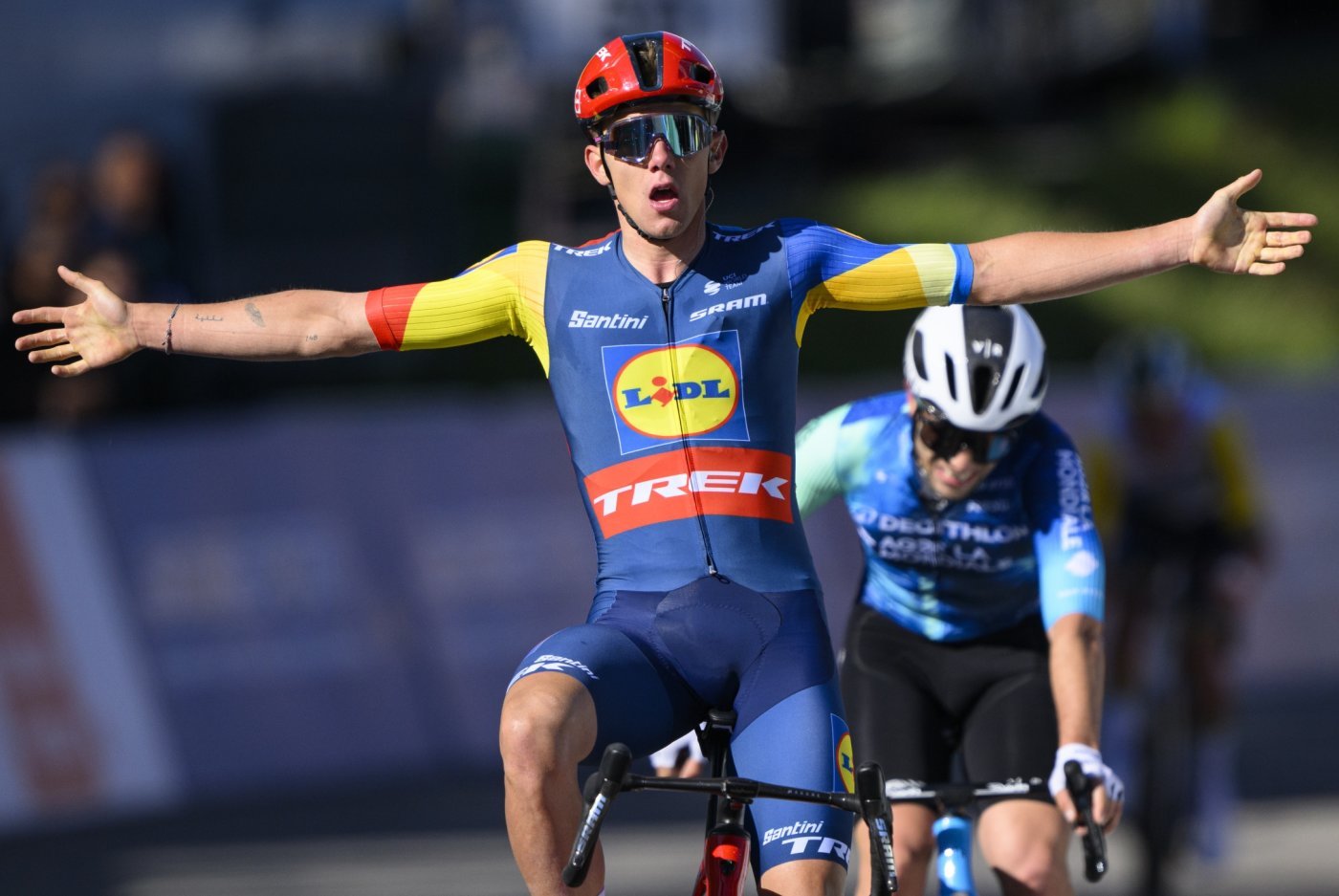 Thibau Nys, left, from Belgium of team Lidl-Trek raises his arms after crossing the finish line to win in front the second placed Andrea Vendrame, right, from Italy of team Decathlon AG2R La Mondiale the second stage, a 171,02 km race between Fribourg and Salvan / Les Marecottes at the 77th Tour de Romandie UCI World Tour Cycling race, in Salvan, Switzerland, Thursday, April 25, 2024. (KEYSTONE/Laurent Gillieron)